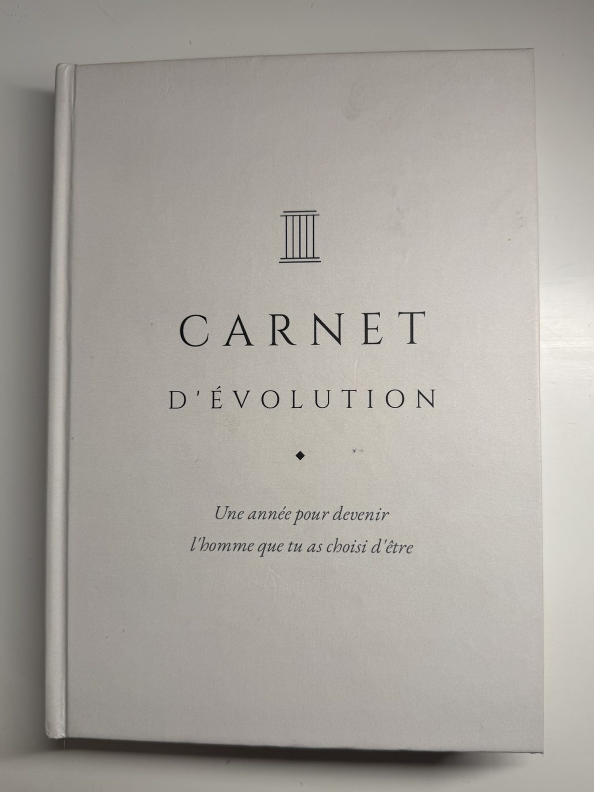 Couverture du Carnet d'évolution, blanche avec une colonne grecque